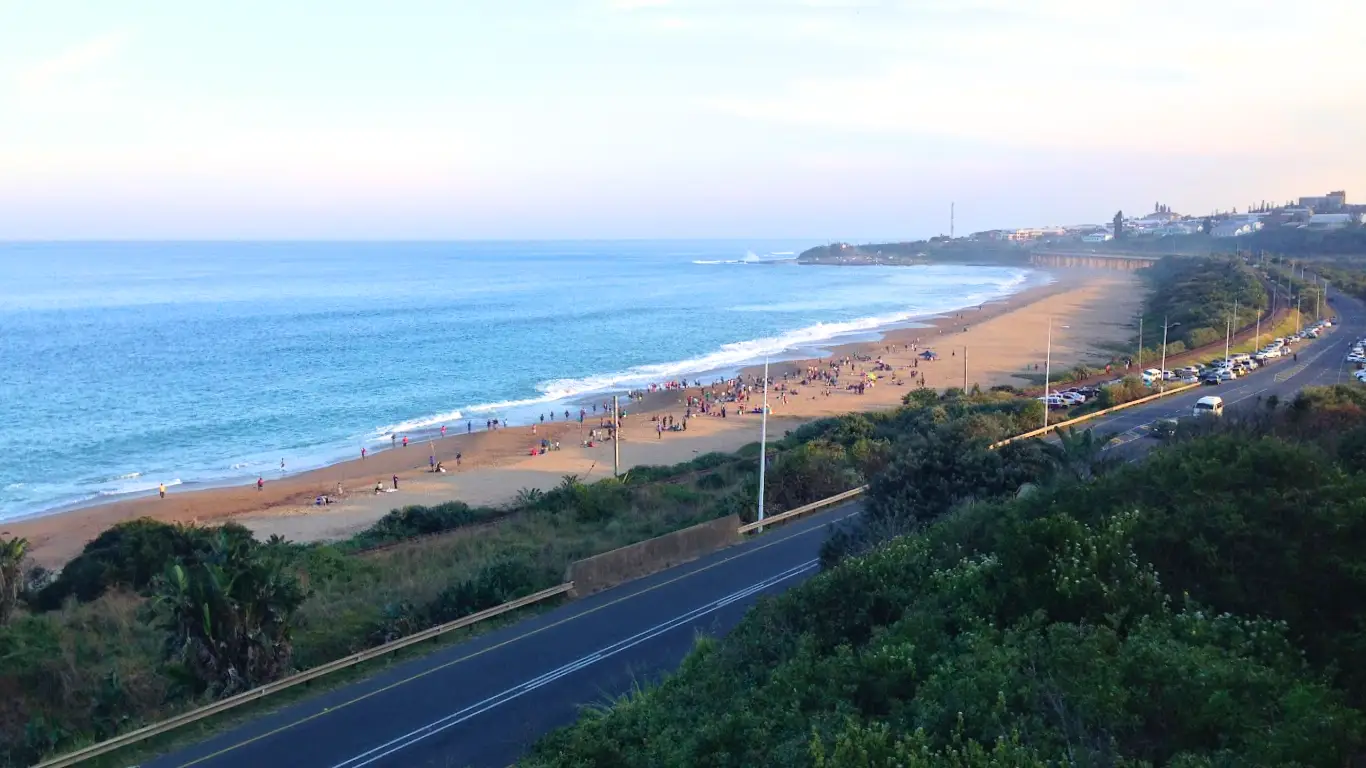 Port Shepstone from Umtentweni Whale Deck showing sandspit, lighthouse and bridge with people on the beach fishing
